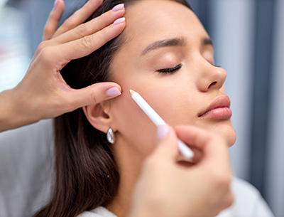 beautician is preparing client's face for procedure