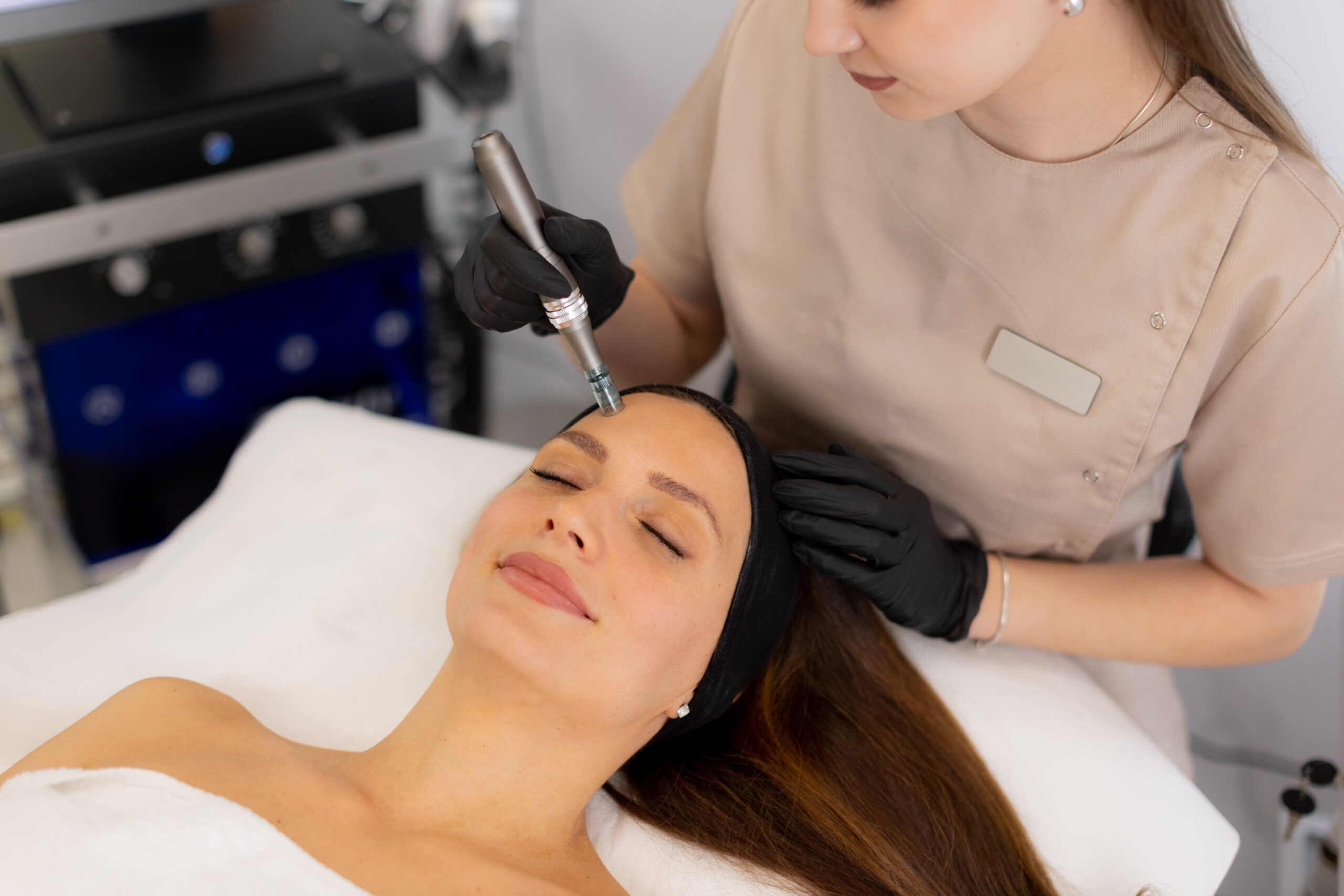 woman receiving a facial treatment from a professional wearing black gloves